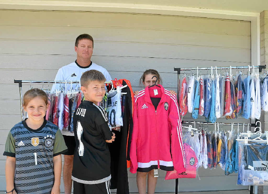 PERSONALISED TOUCH: Tim Gaske (back) with his happy helpers Chloe, Hayden and Macy Gaske show off the football kits for sale.